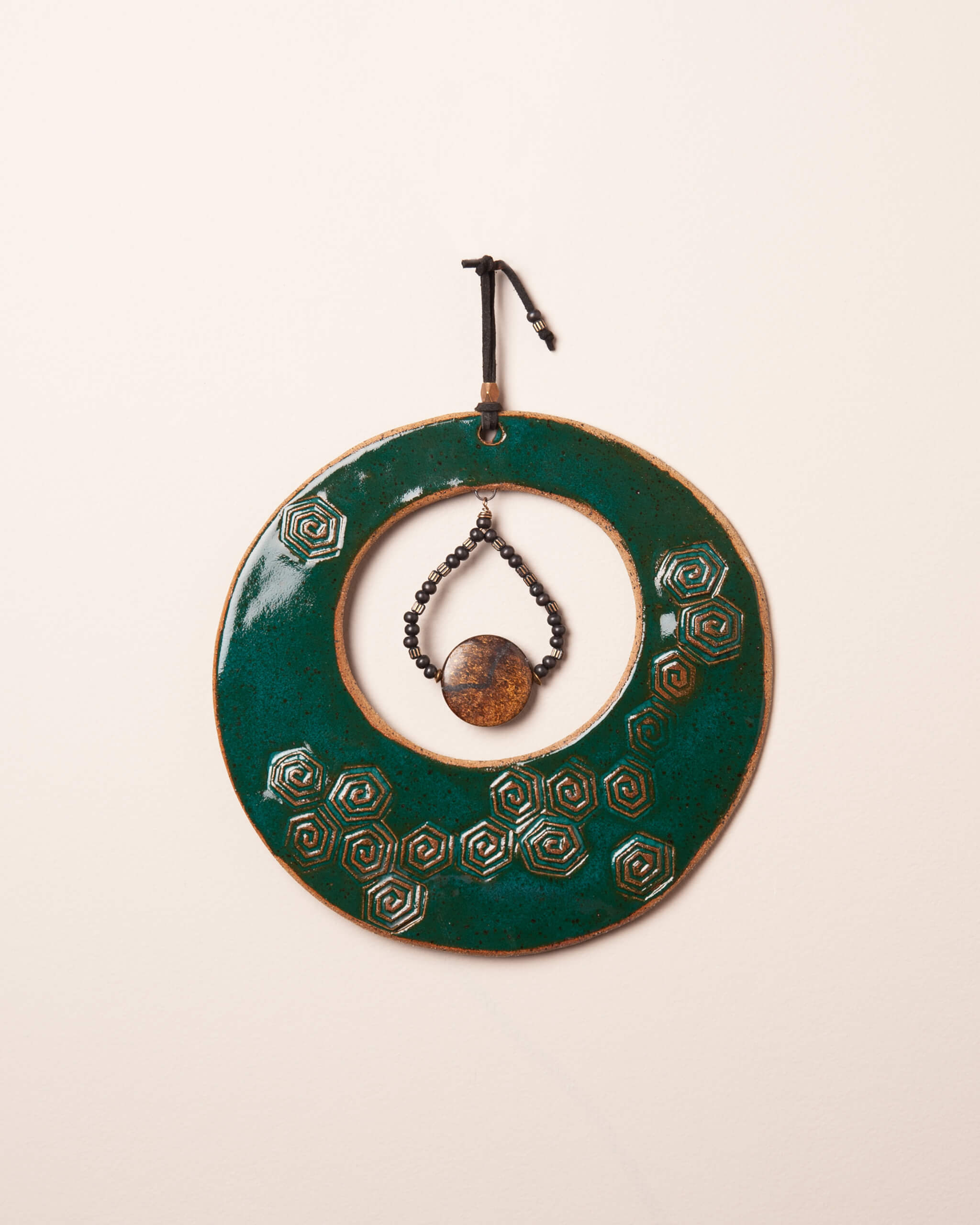 Spiral Tide Moon handmade ceramic wall hanging with spiral hex impression and deep emerald green glaze, made in the Santa Cruz Mountains of California
