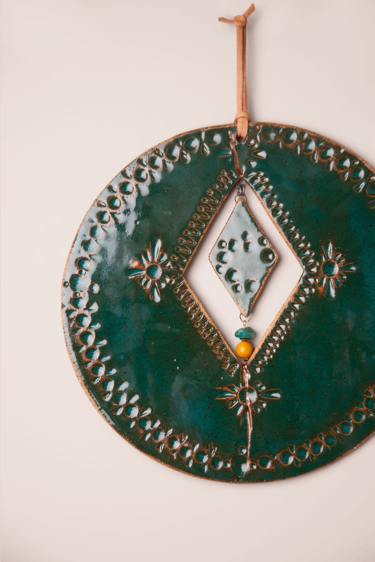 Detail of the gold filled crack and dotted border on a large handmade round ceramic wall hanging, kiln fired by Jester Swink, Santa Cruz Mountains California