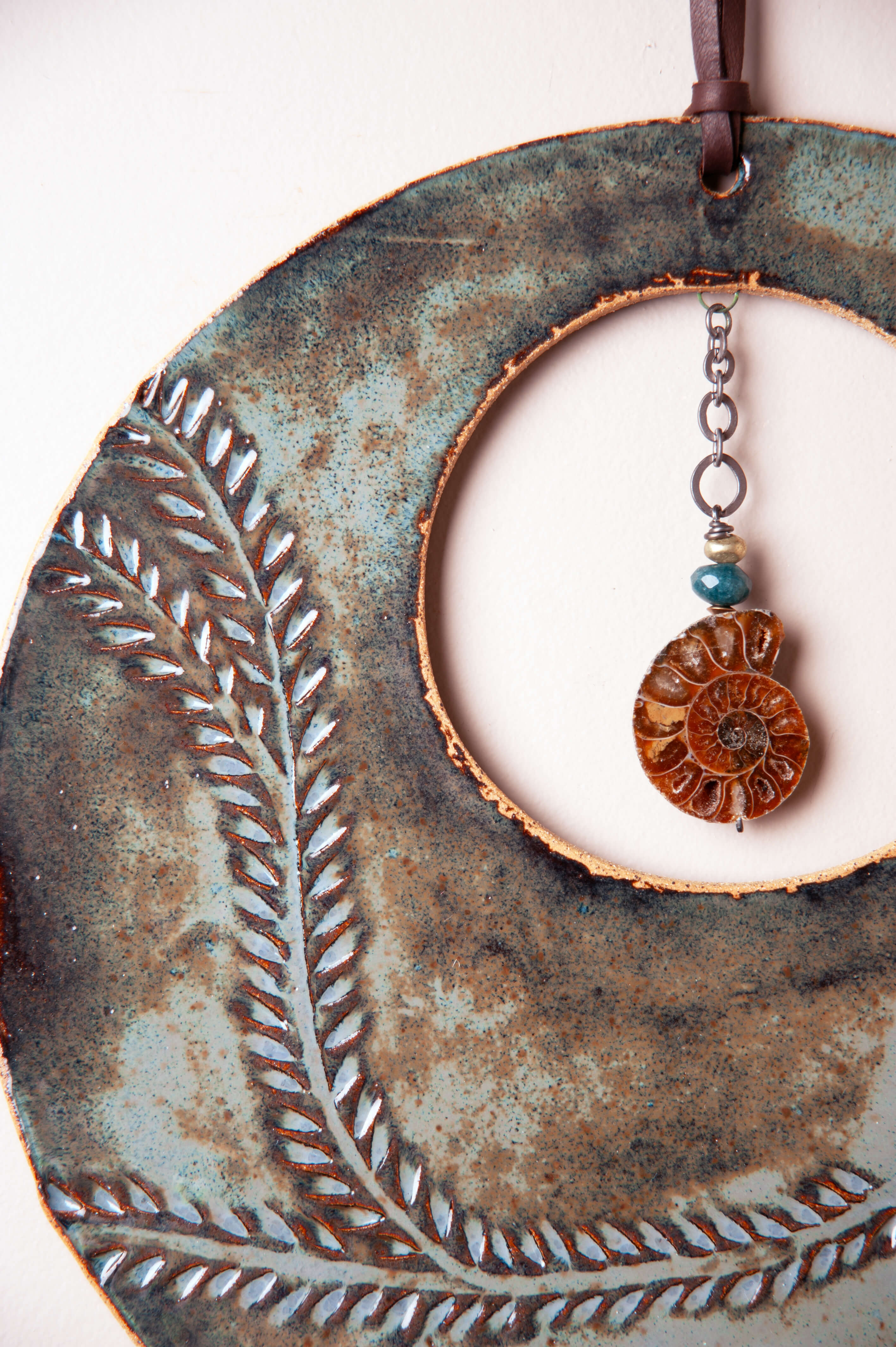 Detail of hand carved vine leaf pattern with aqua marine patina glaze on large handmade ceramic wall hanging by Jester Swink, Santa Cruz Mountains California