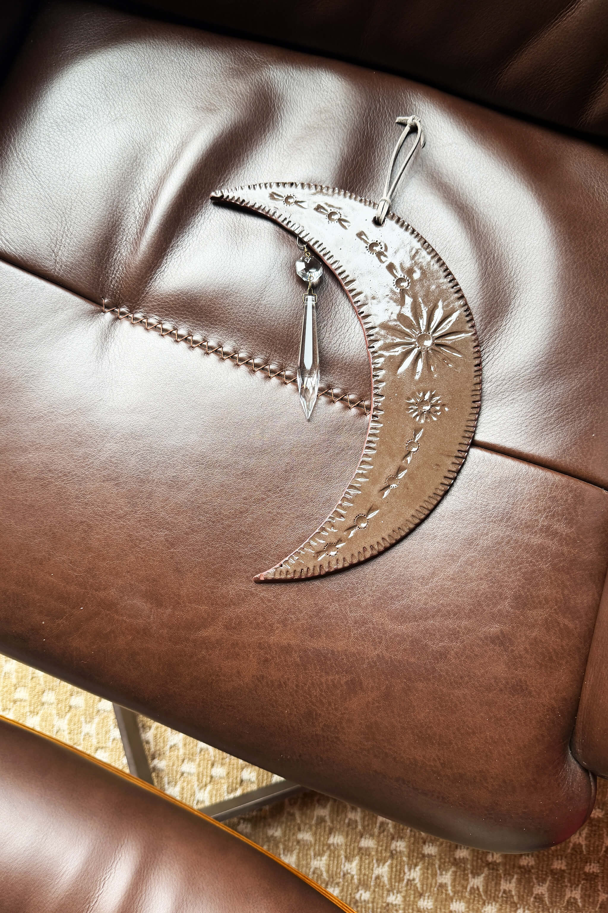 Detail of handmade ceramic crescent moon wall hanging with floral mountain stampings and vintage crystal on leather — From the Fire FTF_0726 by Jester Swink