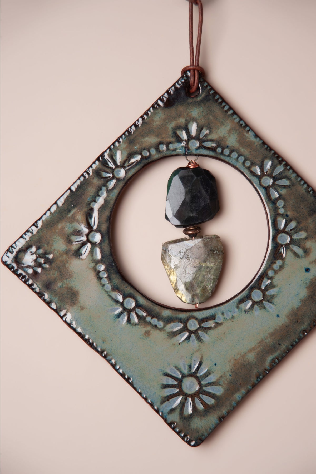Detail of the onyx and labradorite stones in the window of a large handmade diamond ceramic wall hanging, kiln fired by Jester Swink, Santa Cruz Mountains California