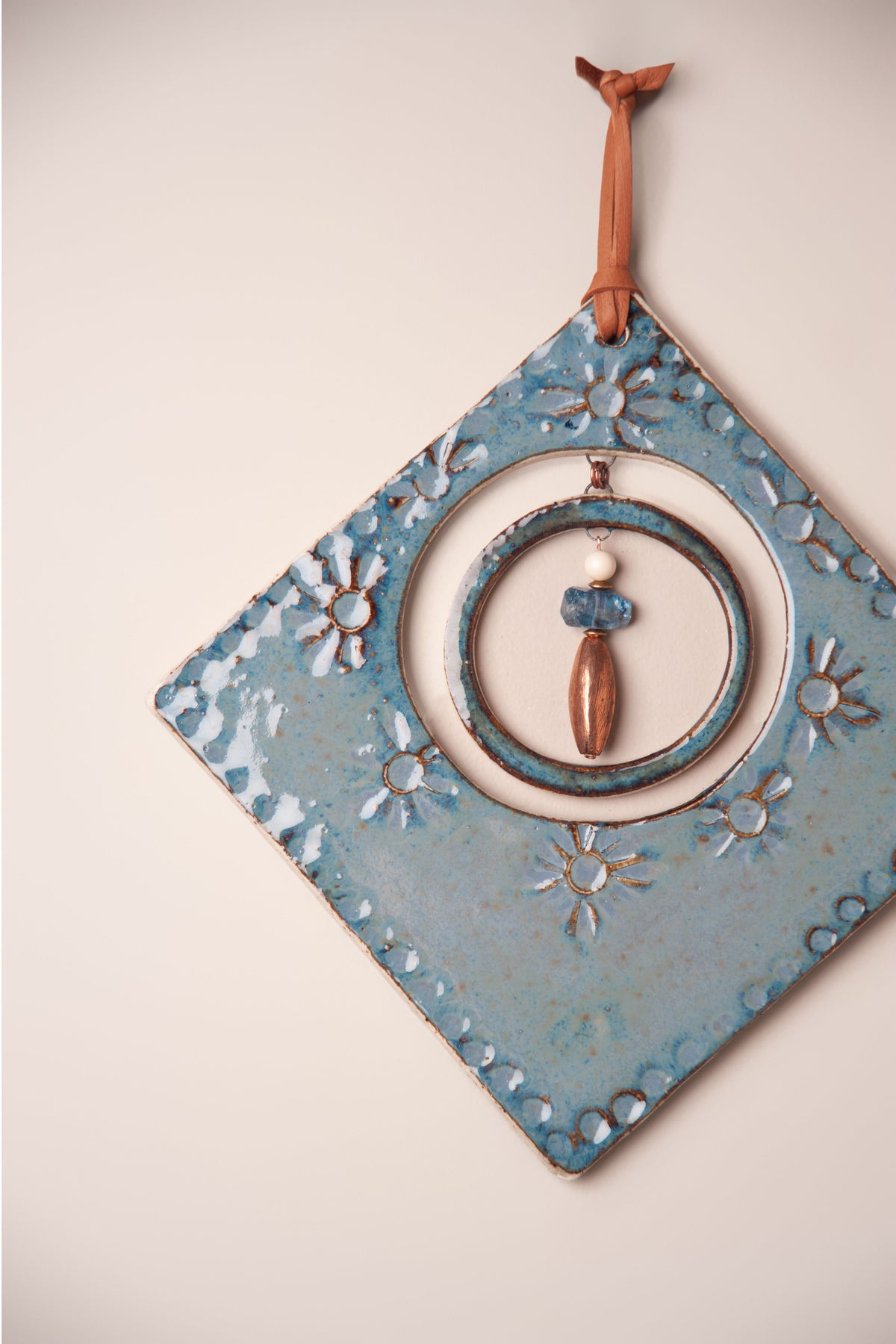 Detail of pressed flowers and dotted border on a large handmade diamond ceramic wall hanging, kiln fired by Jester Swink, Santa Cruz Mountains California