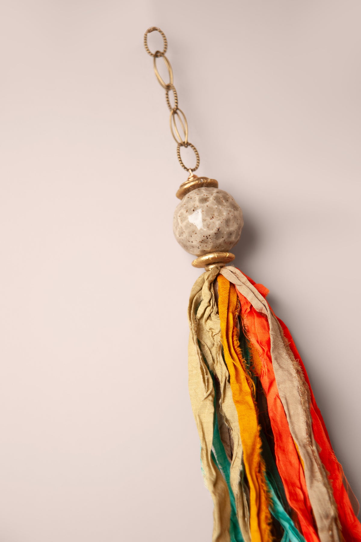 Detail of the raw silk ribbons and ceramic bead on a large handmade windcatcher, made by Jester Swink, Santa Cruz Mountains California