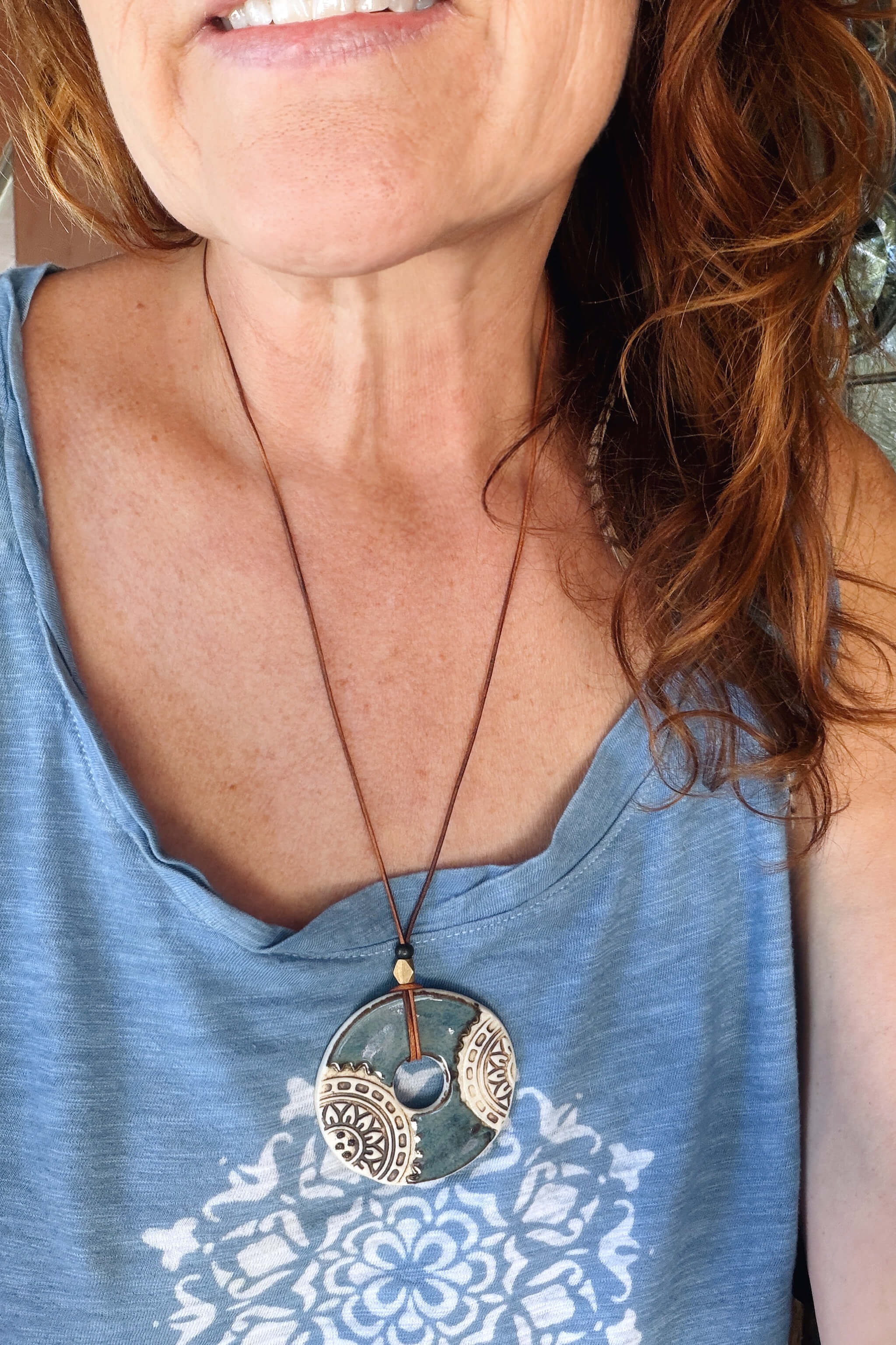 Handmade blue and white mandala ceramic pendant necklace worn at long boho layering length on caramel leather — From the Fire FTF_0726 by Jester Swink