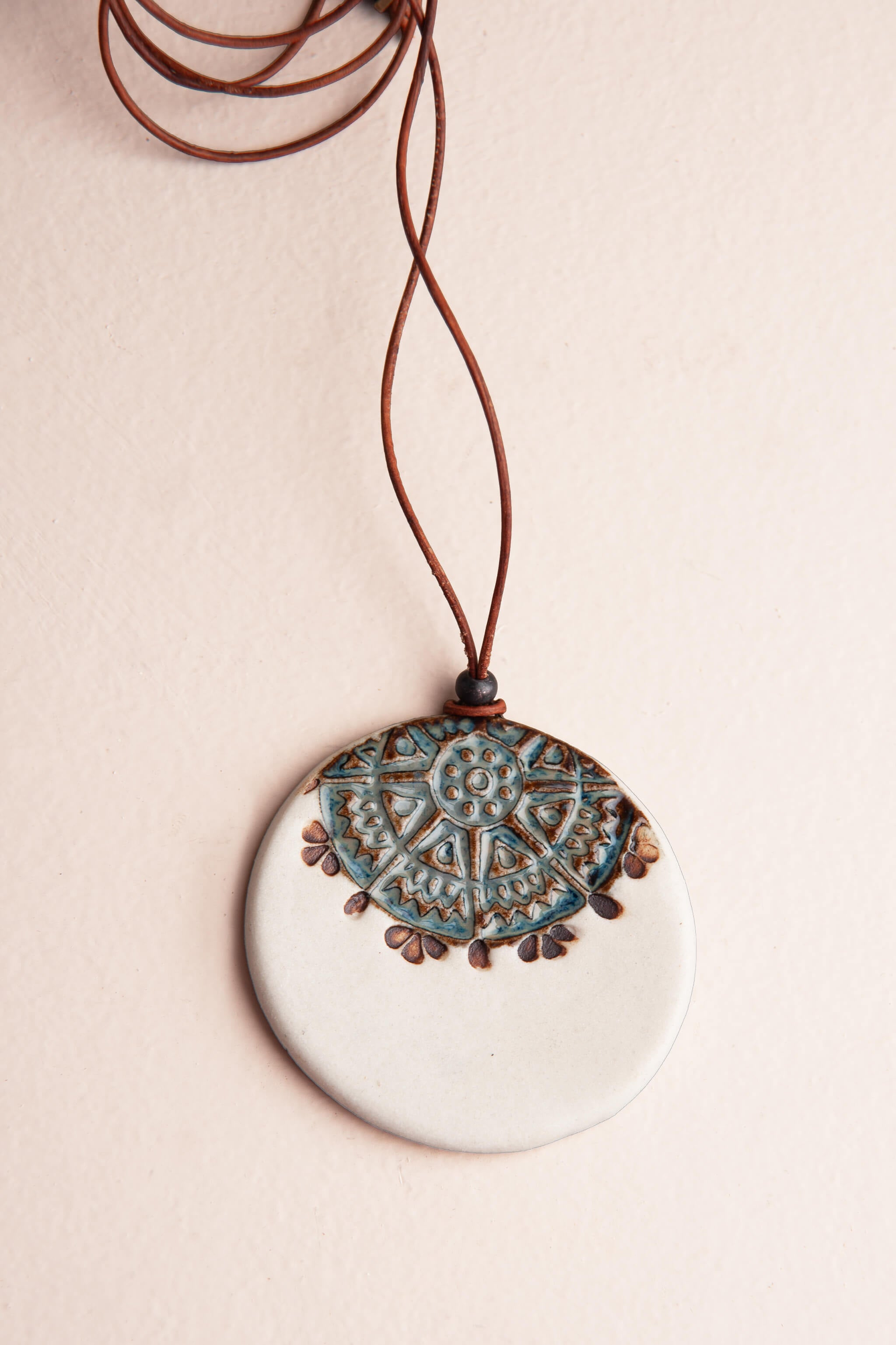 Handmade white porcelain mandala ceramic pendant necklace in antique aqua with brown underglaze on reddish brown Italian leather, kiln fired by Jester Swink Santa Cruz Mountains — From the Fire FTF_0726