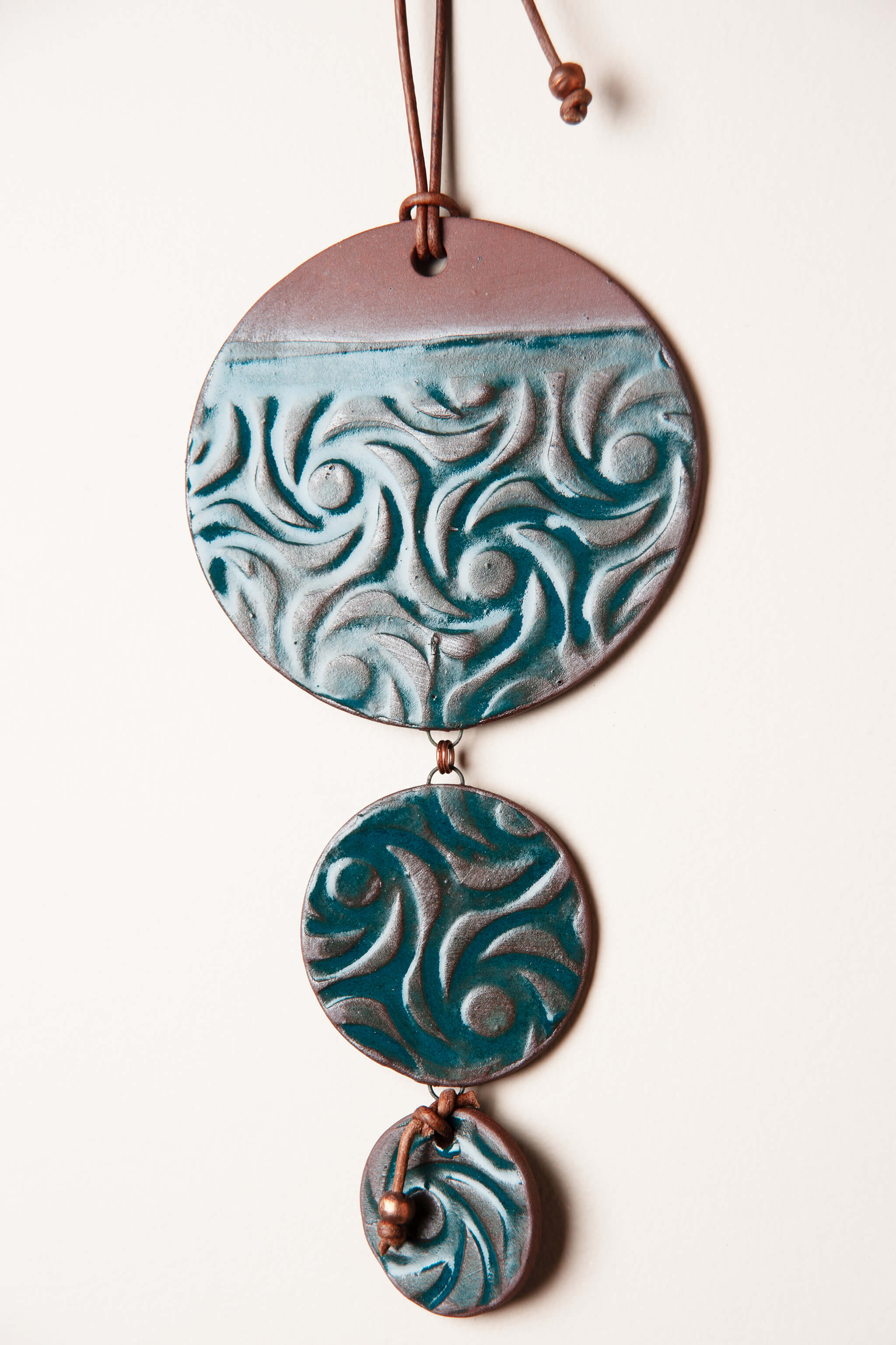 Detail of swirl pattern with marine teal metallic glaze reaction on handmade cascading wall hanging by Jester Swink, Santa Cruz Mountains California