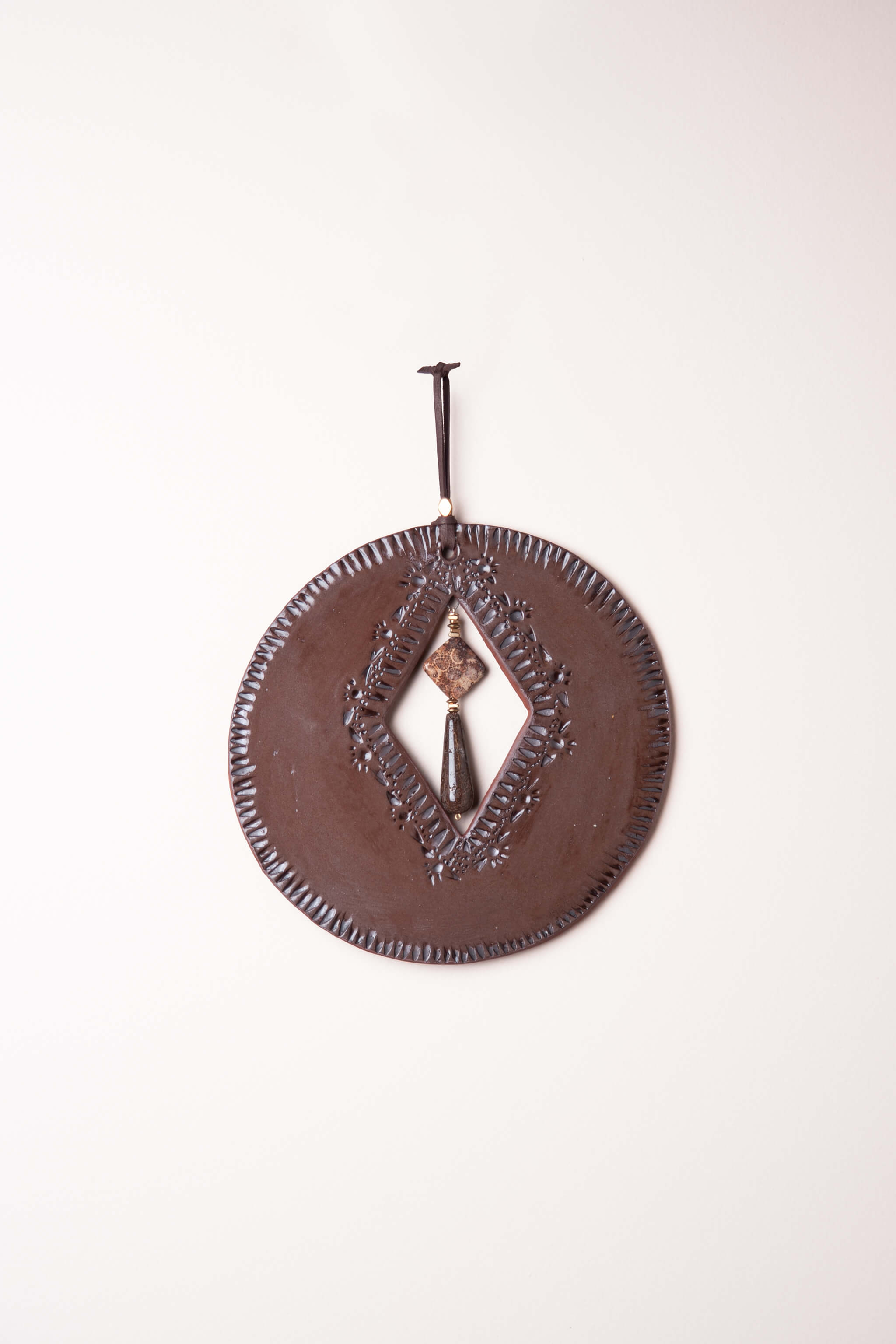 Medium handmade circle ceramic wall art in chocolate brown with sunrise mountain tool pattern and fossilized coral agate drop, kiln fired by Jester Swink Santa Cruz Mountains — From the Fire FTF_0726