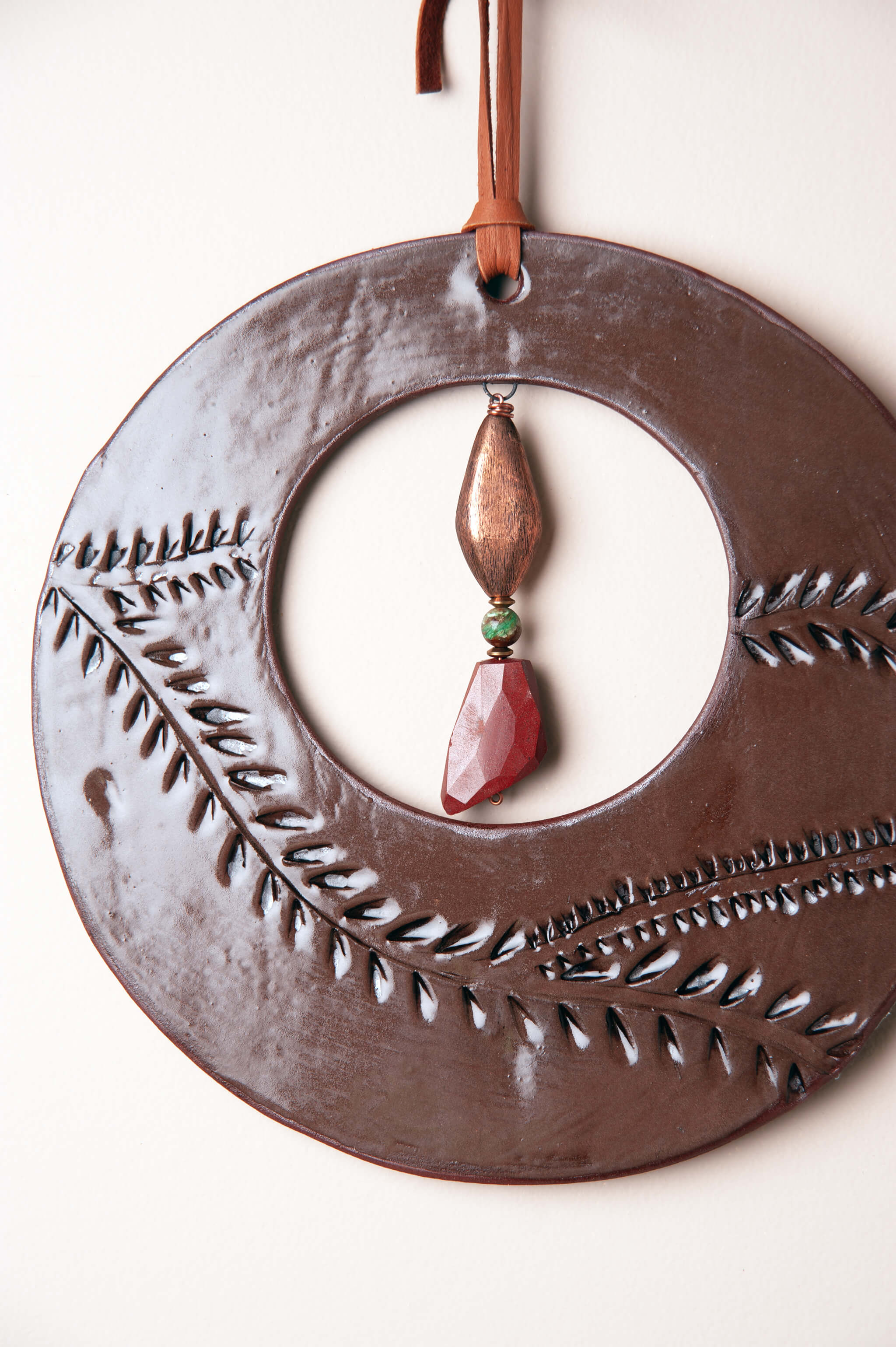 Detail of hand carved vine leaf pattern on medium handmade ceramic wall art by Jester Swink, Santa Cruz Mountains California