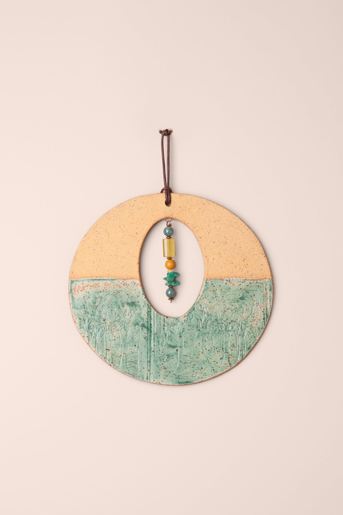 Medium handmade circle ceramic wall hanging in malachite glaze and raw clay with a swirling tree texture, an oval window and a serpentine, amazonite, jade and mookaite dangle, kiln fired by Jester Swink Santa Cruz Mountains — From the Fire FTF_1026