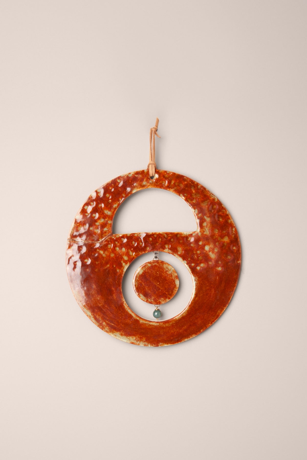 Medium handmade circle ceramic wall hanging in hammered Oolong glaze on porcelain with small hanging moons and an aventurine bead, made in the wabi sabi style by Jester Swink Santa Cruz Mountains — From the Fire FTF_1026