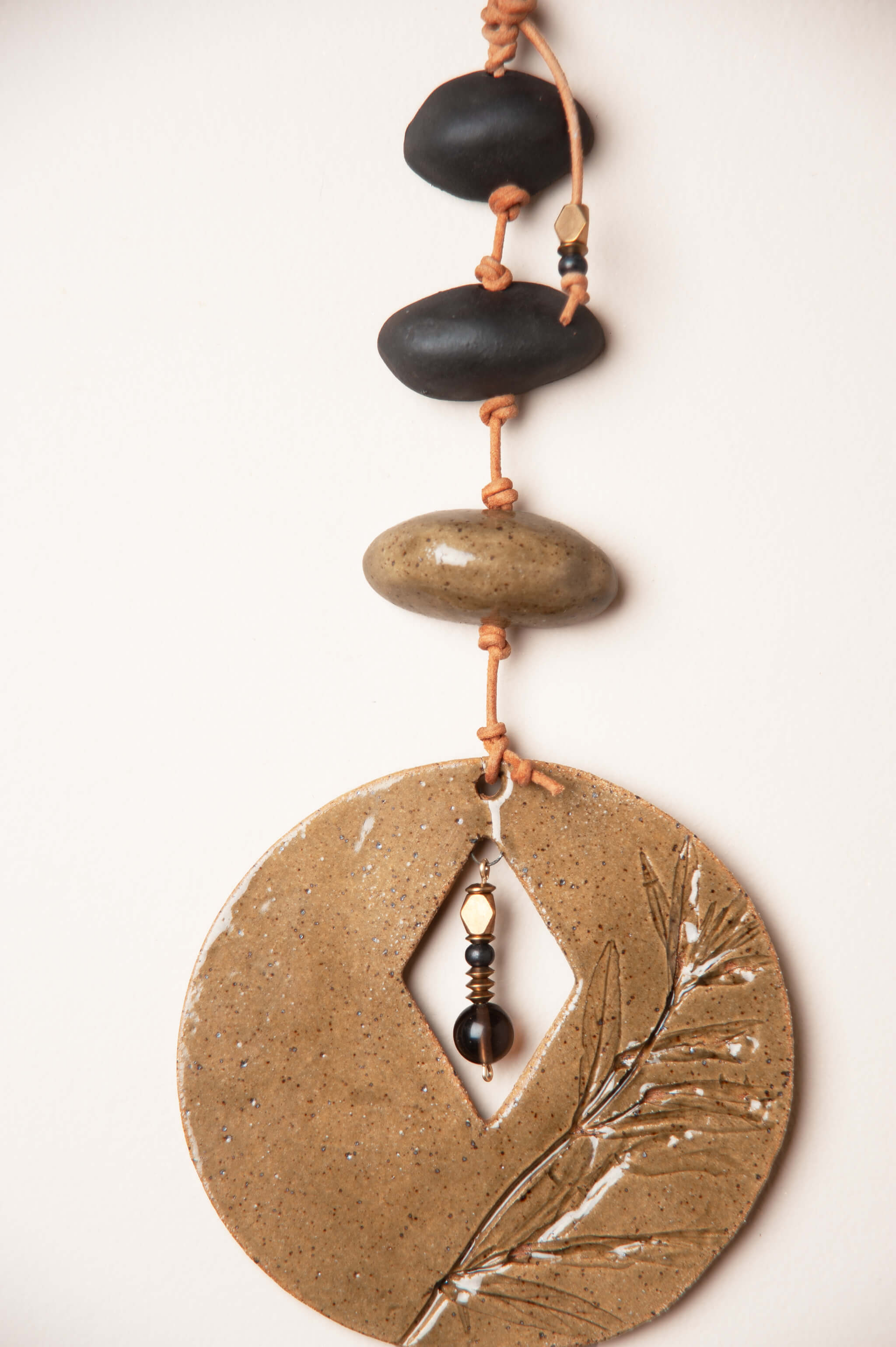 Detail of night clay half beads and olive green speckled buff glaze on handmade ceramic totem wall hanging by Jester Swink, Santa Cruz Mountains California