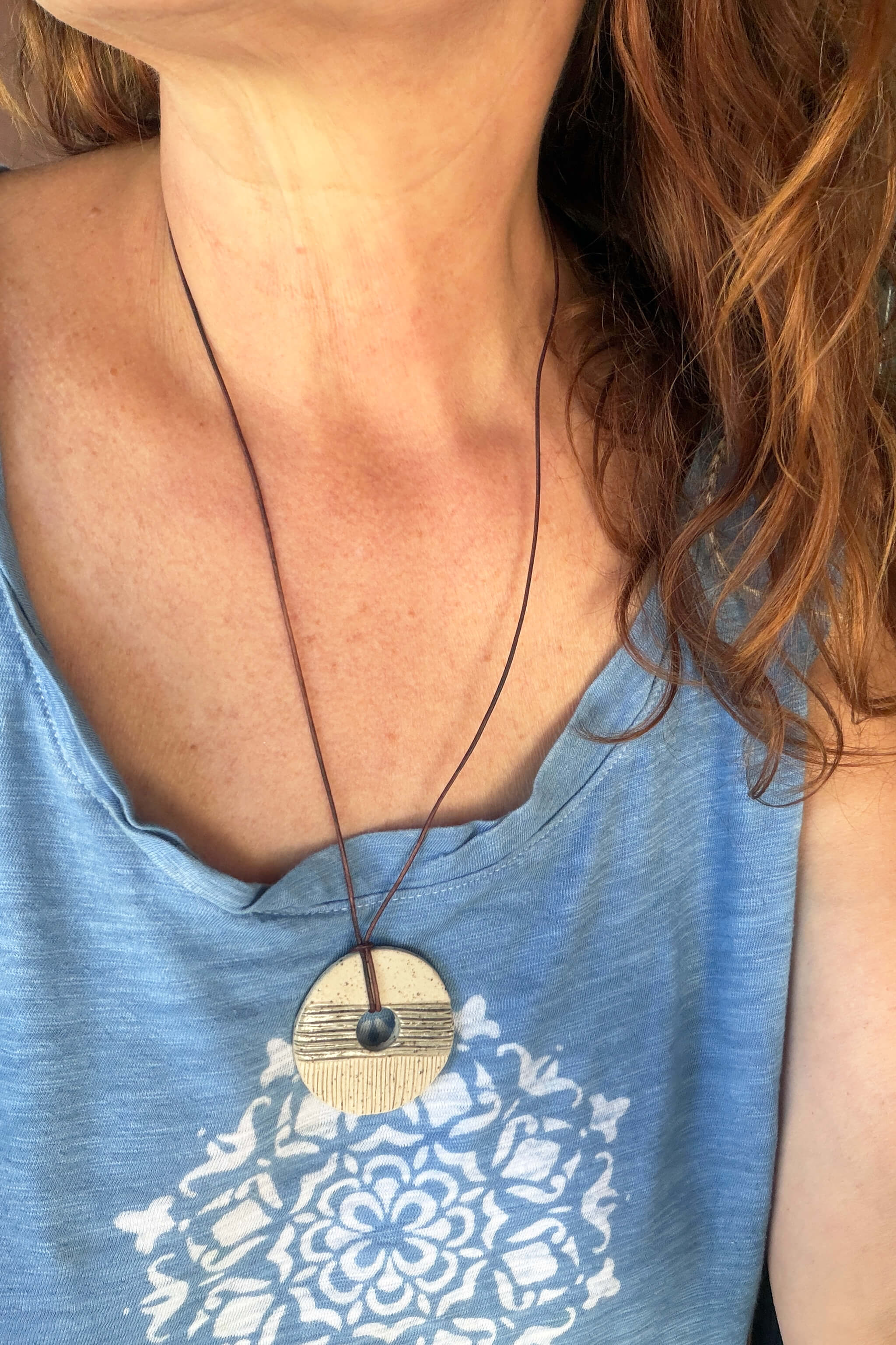 Handmade grey and white ceramic pendant necklace worn long on reddish brown leather — modern minimalist ceramic jewelry From the Fire FTF_0726 by Jester Swink