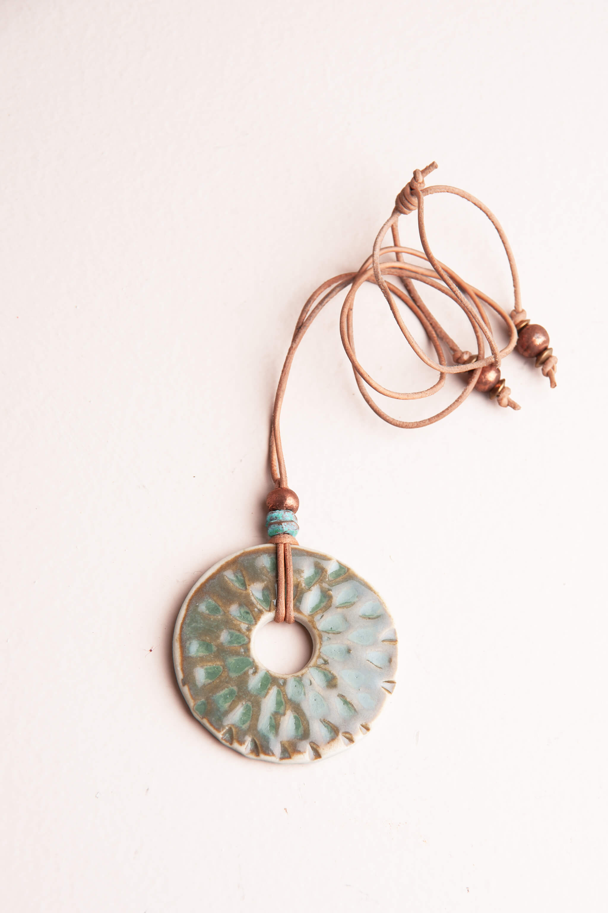 Handmade ceramic raindrop pendant necklace in aquamarine glaze with patina brass beads on caramel Italian leather, kiln fired by Jester Swink Santa Cruz Mountains — From the Fire FTF_0726