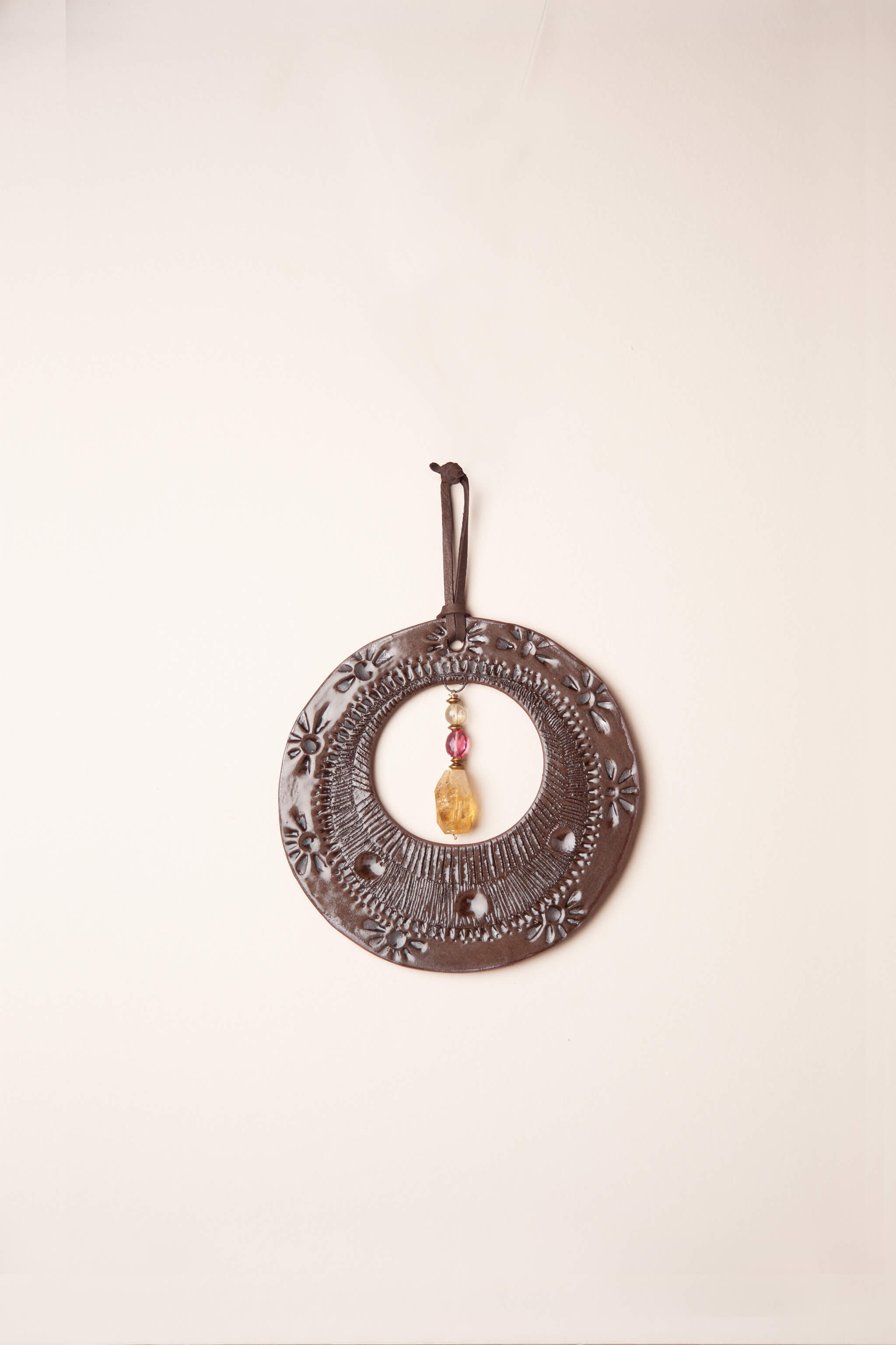 Small handmade southwest inspired ceramic circle wall hanging in chocolate brown with rubelite tourmaline and citrine, kiln fired by Jester Swink Santa Cruz Mountains — From the Fire FTF_0726