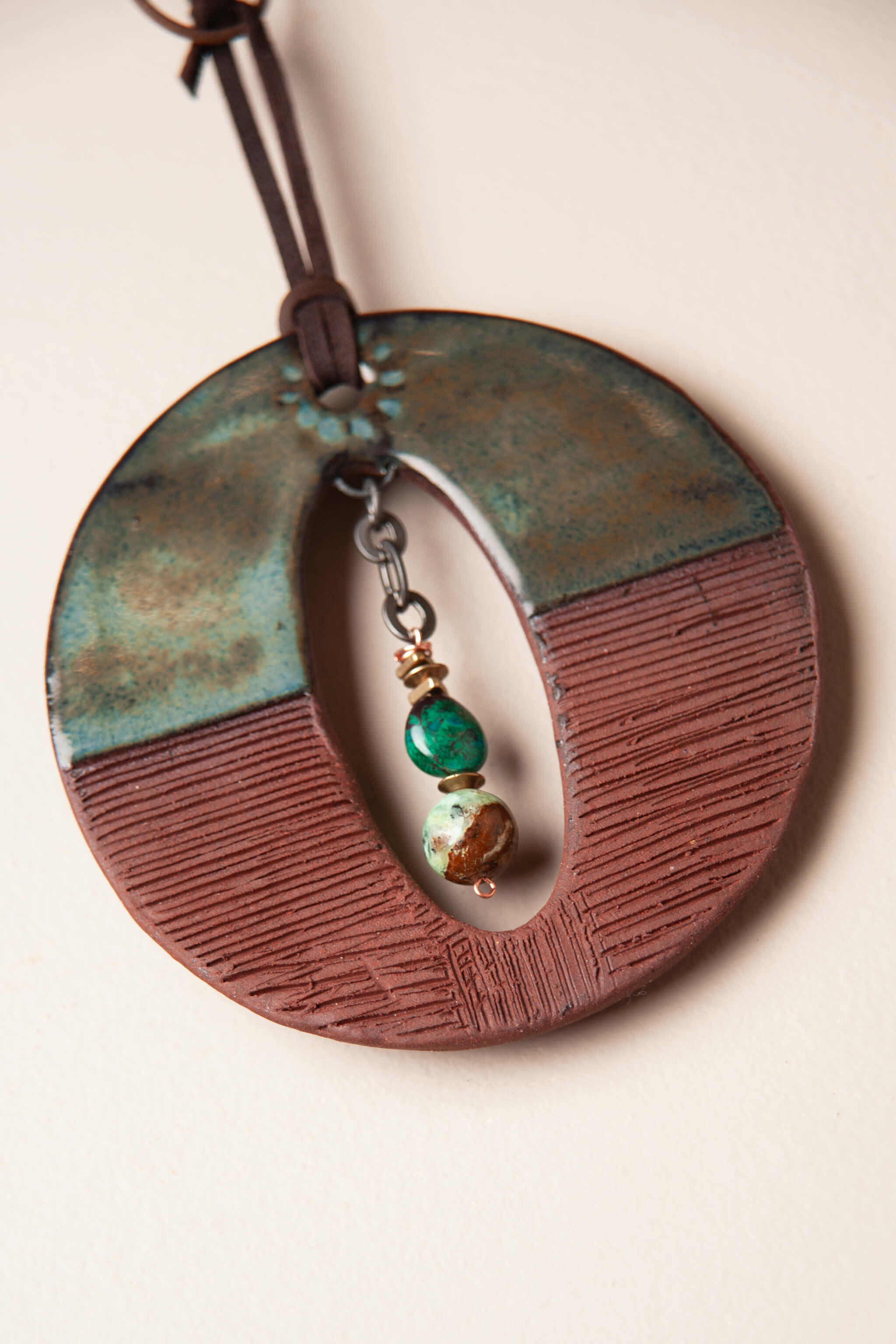 Detail of color block glaze and modern tool pattern lines on small handmade ceramic wall hanging by Jester Swink, Santa Cruz Mountains California