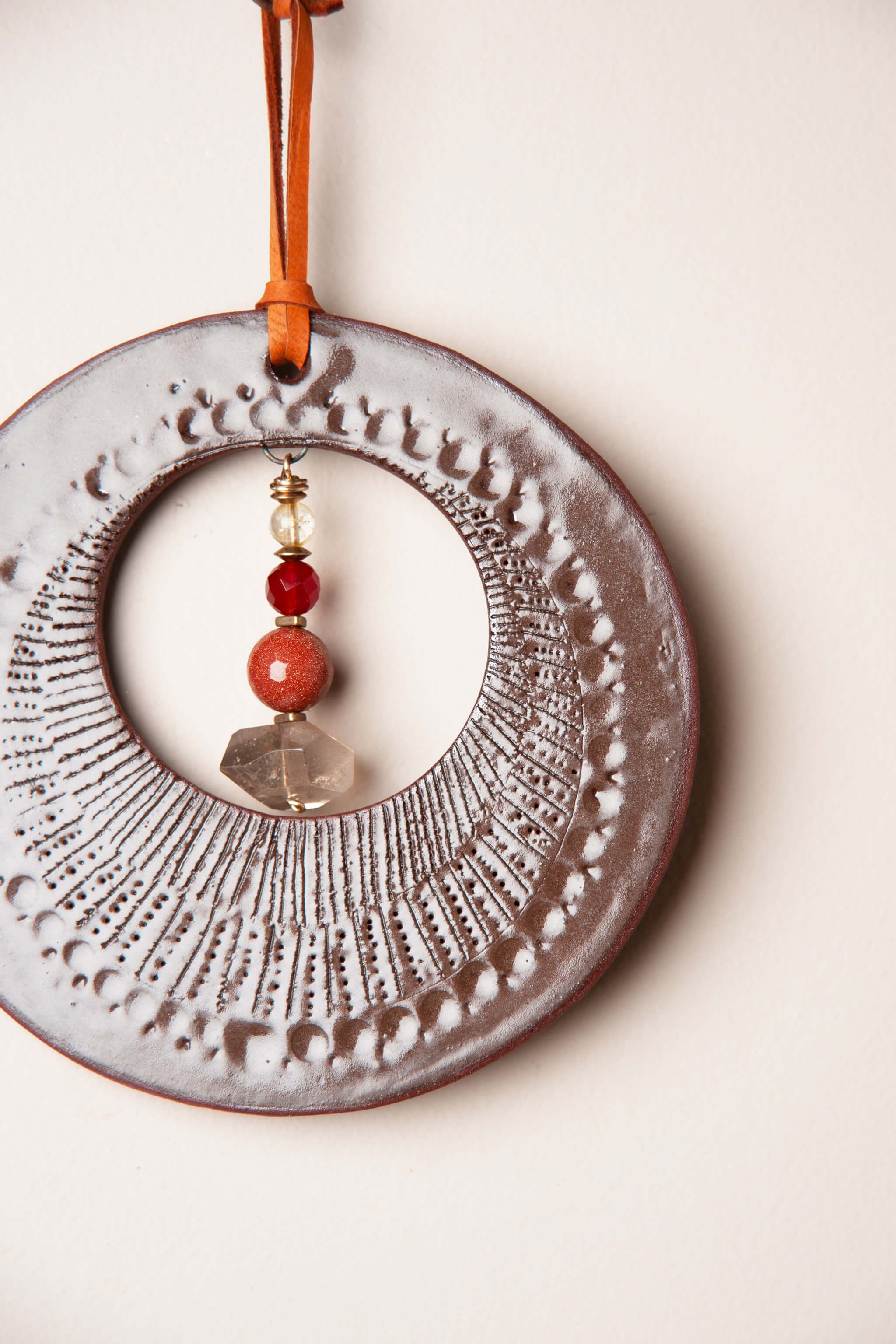 Detail of intuitive hand pressed talisman pattern on small handmade ceramic wall hanging by Jester Swink, Santa Cruz Mountains California