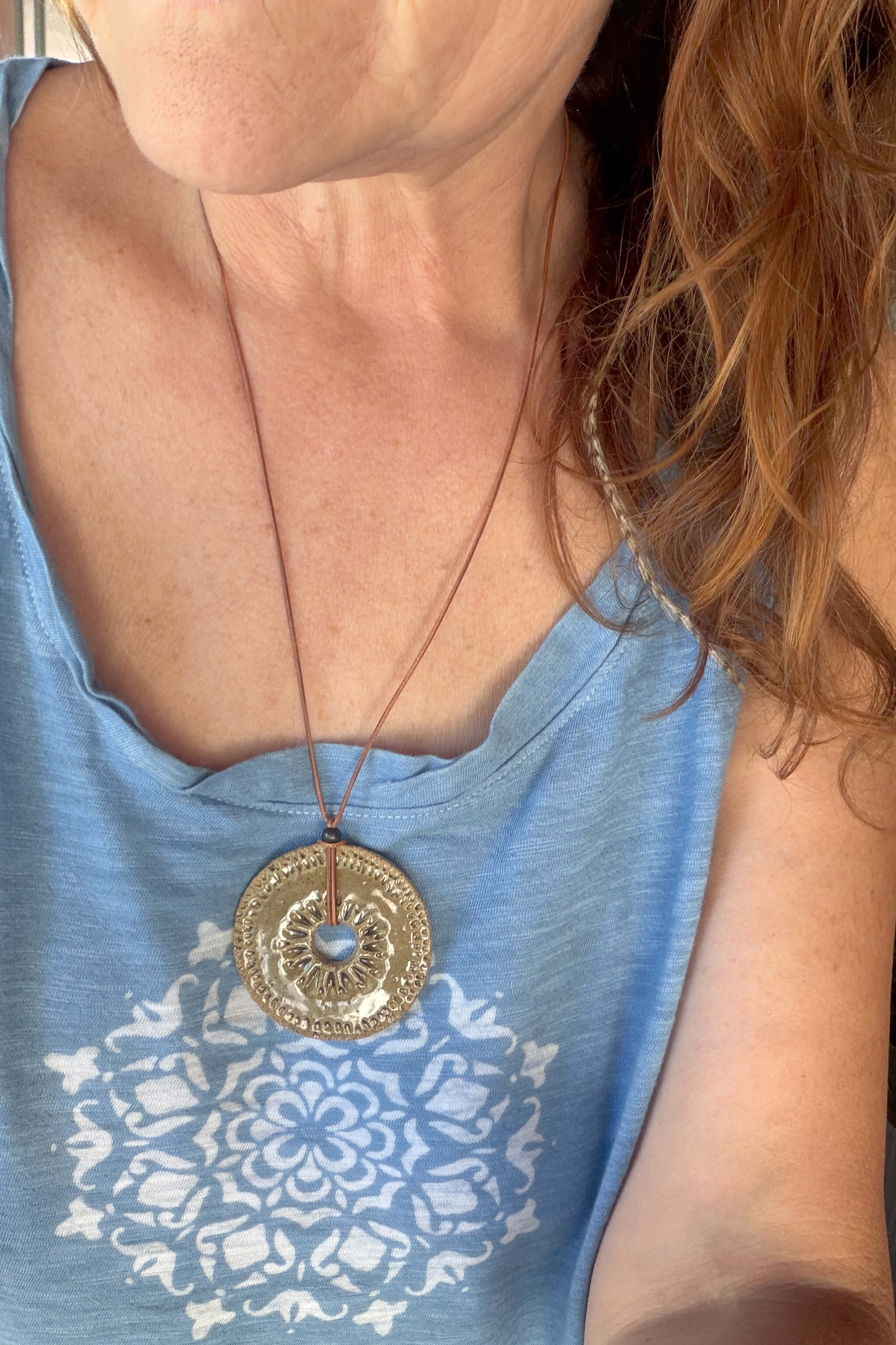 Handmade olive green ceramic sun disc pendant necklace worn at long boho length on caramel leather — earth tone ceramic jewelry From the Fire FTF_0726 by Jester Swink