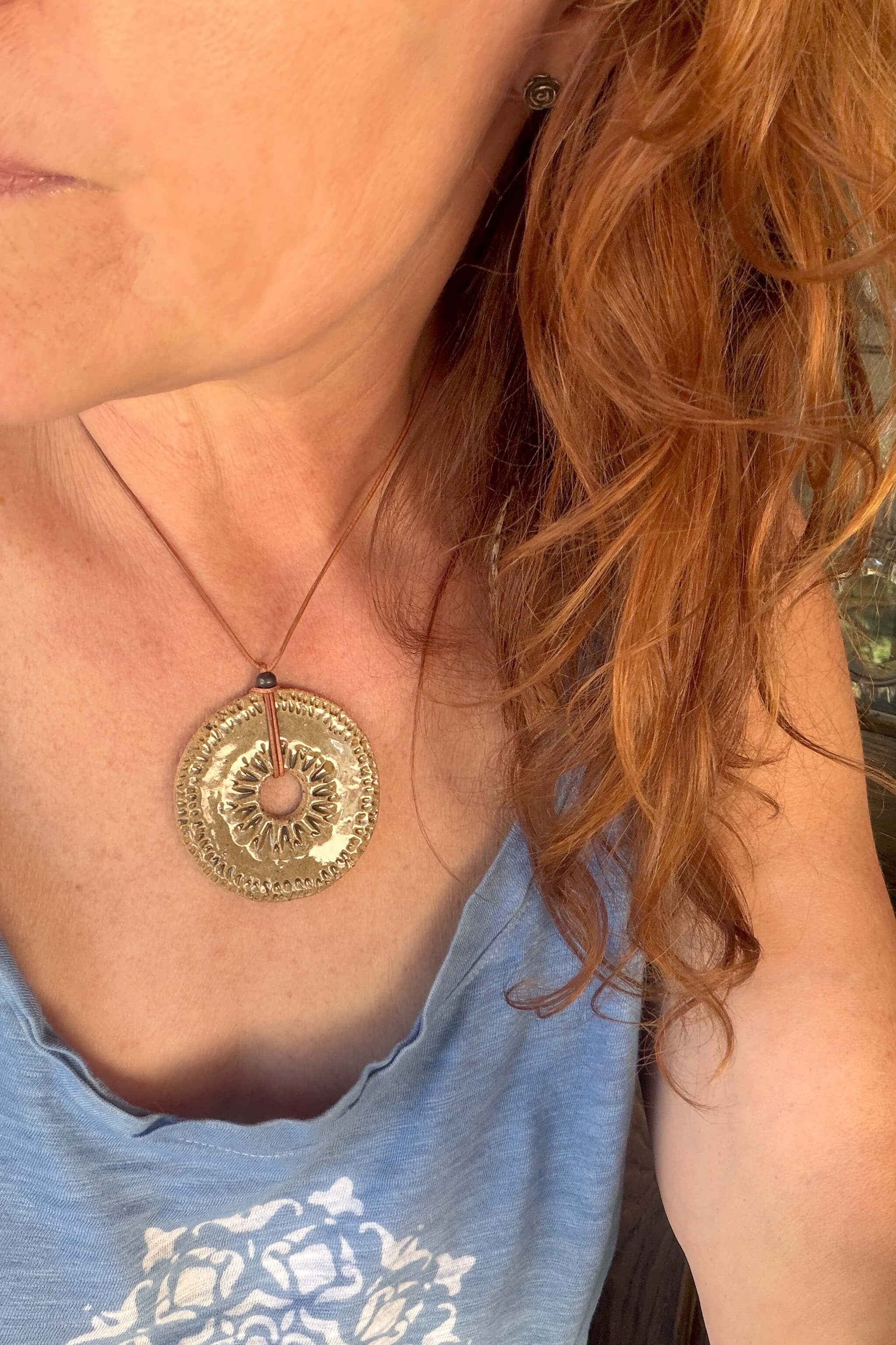 Handmade speckled olive ceramic sunburst pendant necklace worn at shorter length — desert inspired ceramic jewelry From the Fire FTF_0726 by Jester Swink