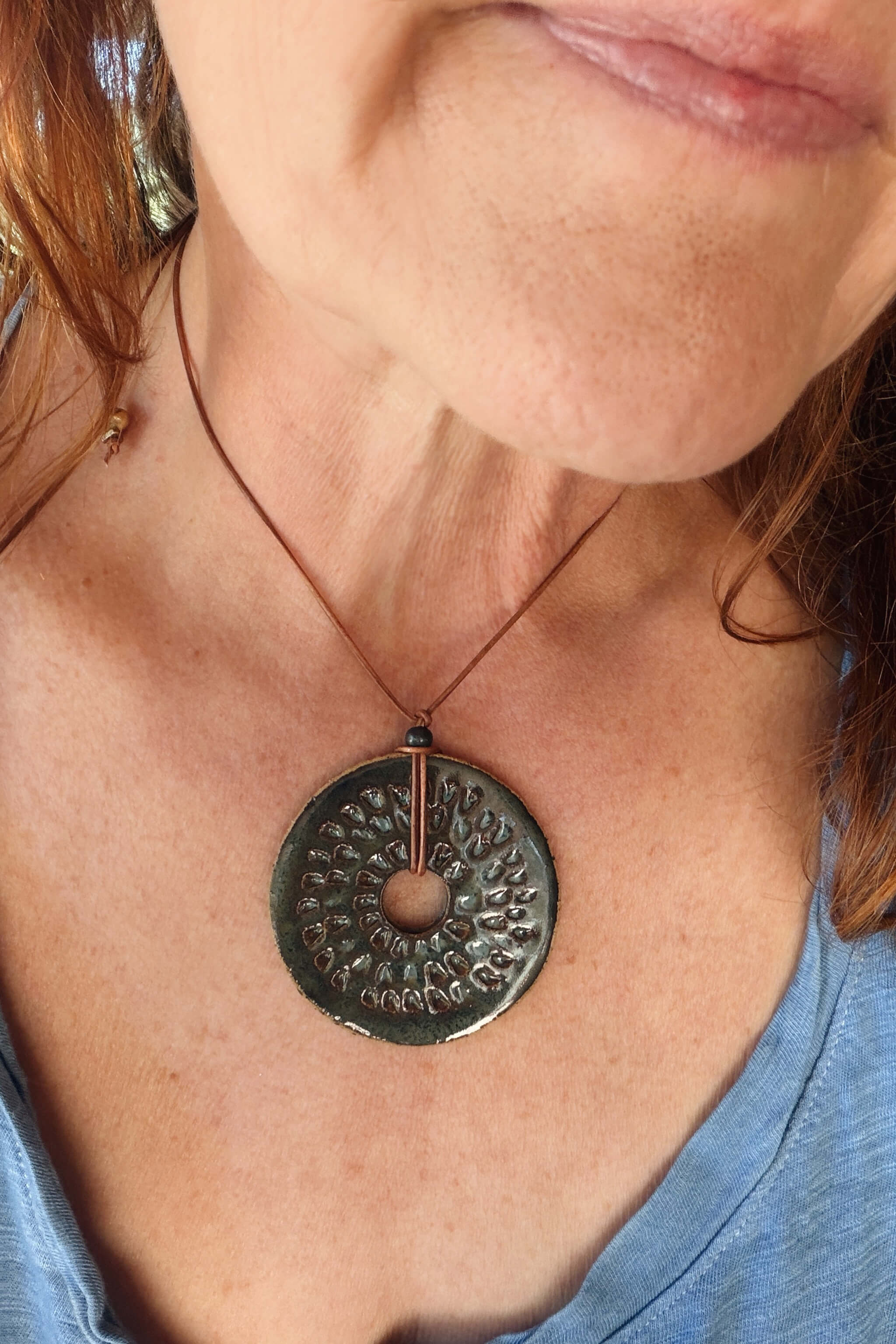 Handmade coastal ceramic sunburst pendant necklace worn at shorter length — aquamarine ceramic jewelry From the Fire FTF_0726 by Jester Swink
