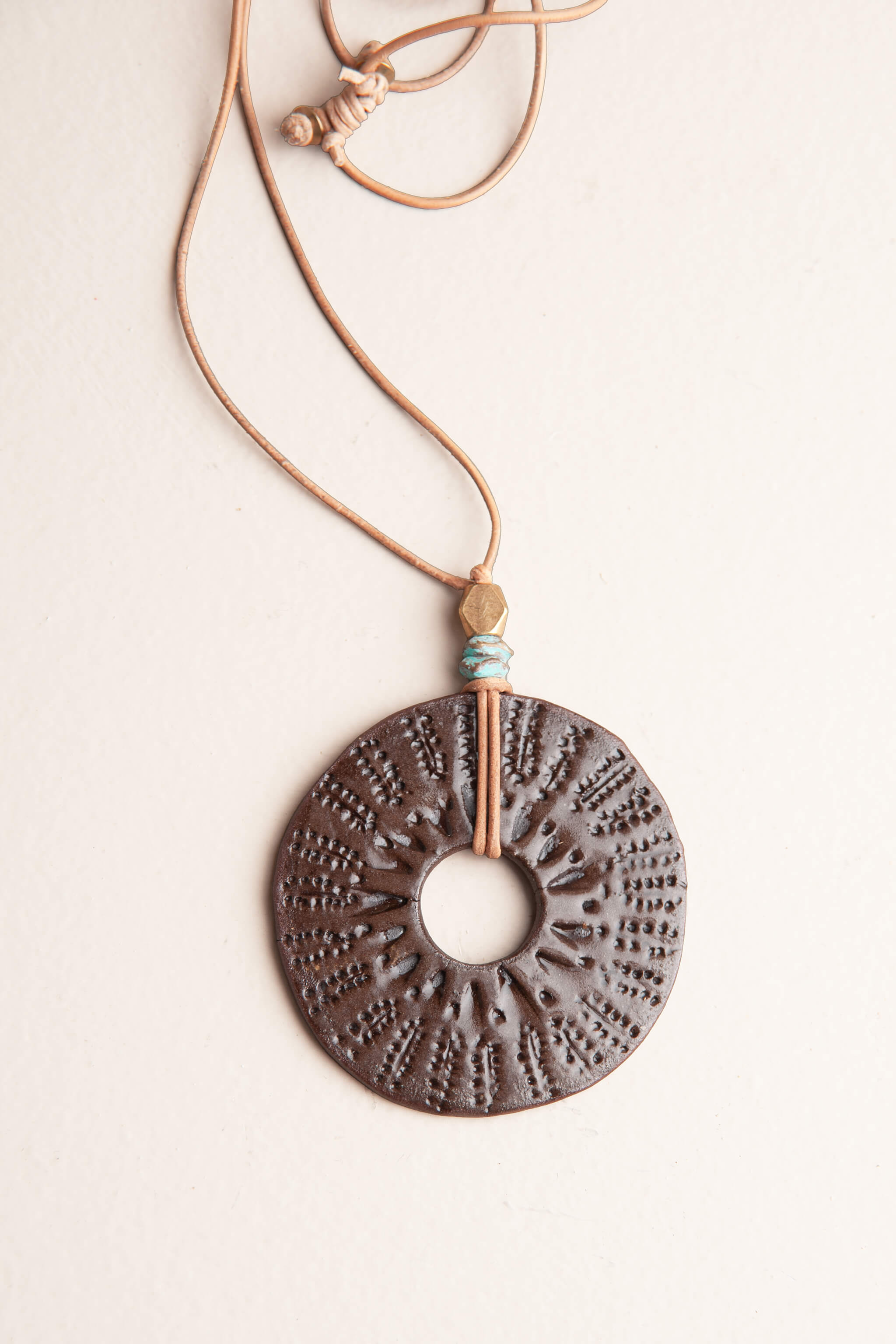 Handmade ceramic sunburst pendant necklace in chocolate brown terracotta with patina brass turquoise beads on natural leather, kiln fired by Jester Swink Santa Cruz Mountains — From the Fire FTF_0726