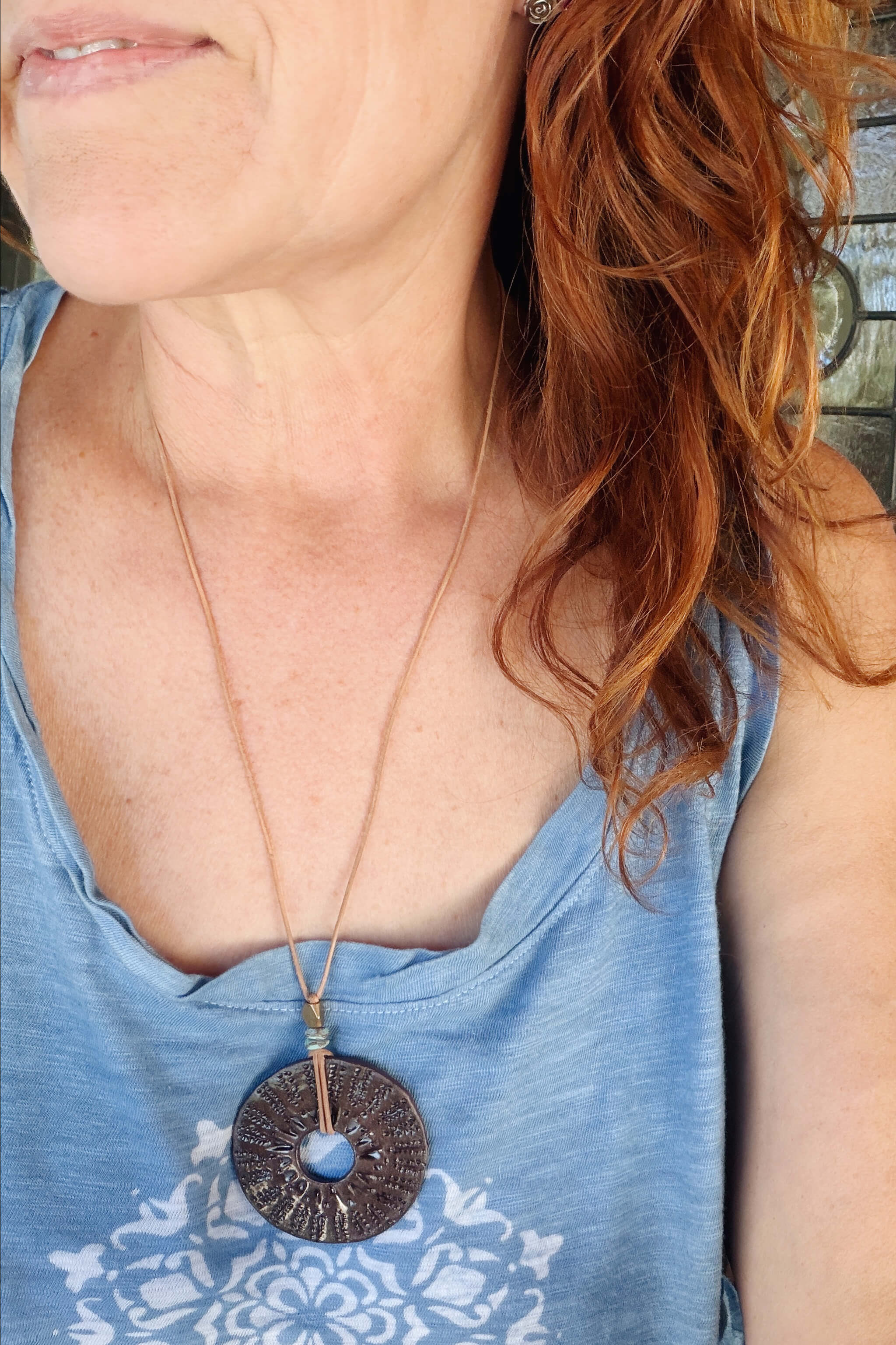 Handmade ceramic sunburst talisman pendant necklace worn at long boho length on natural leather — From the Fire FTF_0726 by Jester Swink