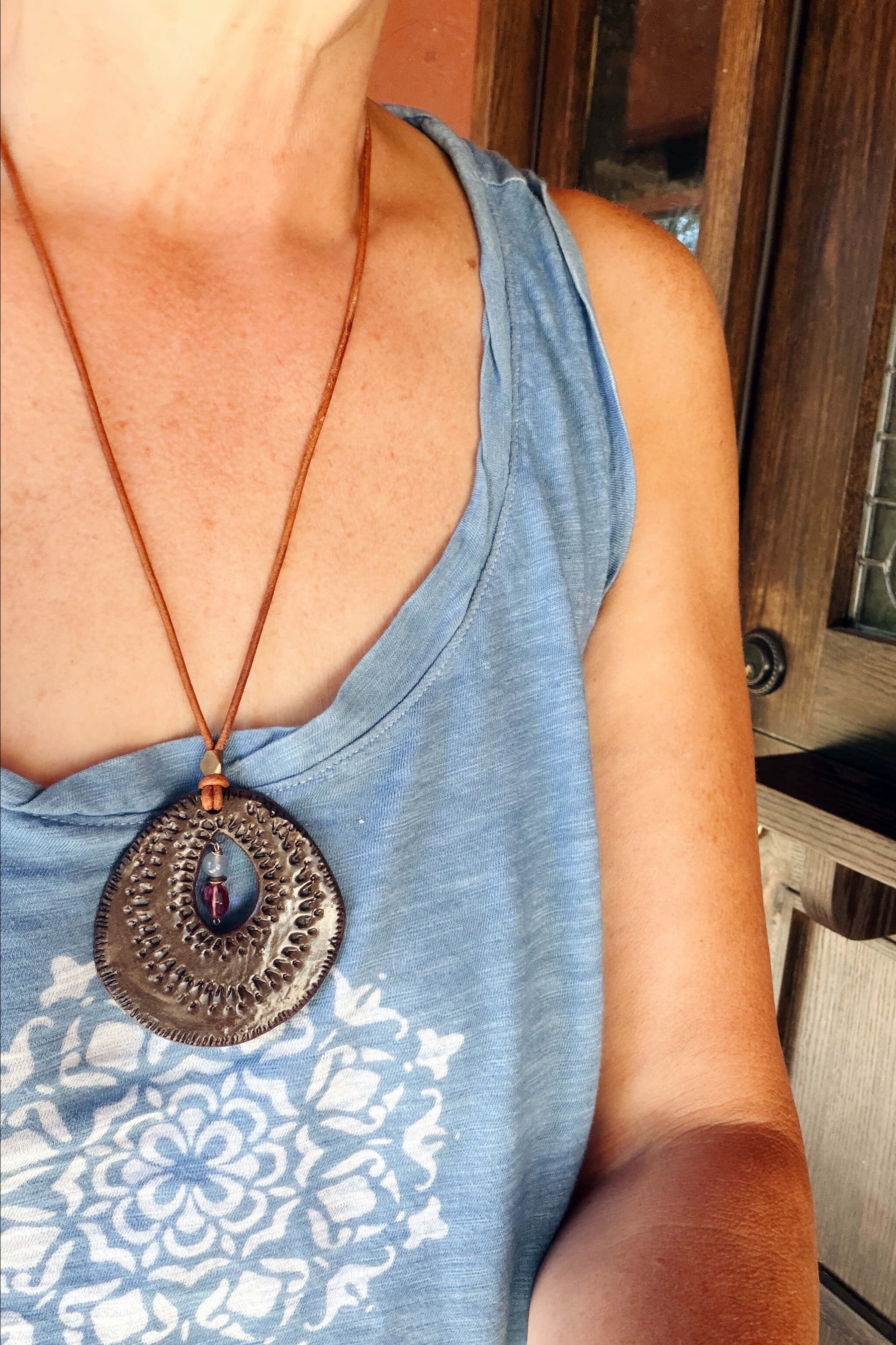 Handmade ceramic sunburst pendant necklace worn at long boho length on adjustable Italian leather — From the Fire FTF_0726 by Jester Swink
